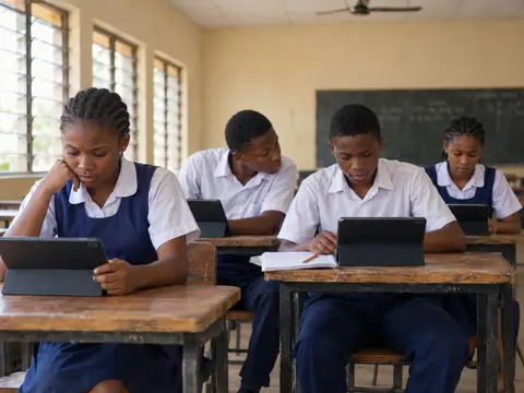 Secondary school students working on tablets at their classroom desks